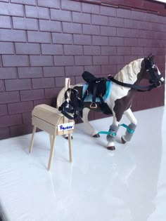 a toy horse pulling a miniature chair on top of a table