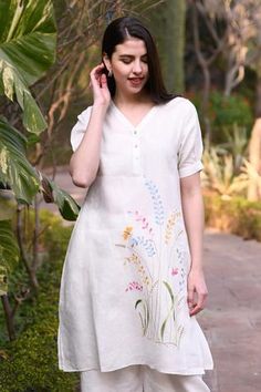 Ivory kurta with placement floral embroidery and side slits.
Components:1
Embroidery
Neckline:V neck
Sleeve Length:Short
Fabric:100% Linen
Color:White
Closure: Front button placket
Note: Pants worn by model are for styling purpose only. - Aza Fashions Cotton Suit Designs, Chudidhar Neck Designs, Kurta Women, Fabric Painting On Clothes, Kurta For Women, Stylish Short Dresses, Kurta Neck Design, Cotton Kurti Designs, Embroidery Works