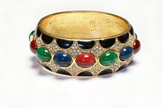 Vintage Ciner Bracelet.Indulge in luxury with our exclusive Vintage Ciner Mughal Style Bangle Bracelet. Adorned with vibrant red, blue, and green cabochon glass and enamel, this bracelet exudes sophistication and artistry. Elevate any outfit with this unique and timeless piece. Approximate Measurements: best suitable for a small wrist. Luxury Multicolor Cabochon Bracelet, Designer Enamel Bangle Jewelry, Multicolor Jeweled Enamel Jewelry, Round Jeweled Enamel Jewelry, Luxury Multicolor Enamel Jewelry, Formal Jeweled Enamel Jewelry, Formal Enamel Bangle, Elegant Multicolor Enamel Bangle, Formal Round Enamel Bangle