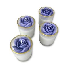 three white cups with blue flowers in them on a white surface, one has gold rims and the other has a purple rose