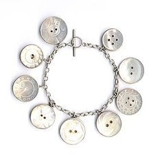 a silver bracelet with buttons on it and a cross in the middle, all connected by a chain