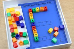 an infant's toy tray with legos on it and a matching letter puzzle