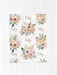 a white towel with flowers and the words lily on it, in gold foil lettering