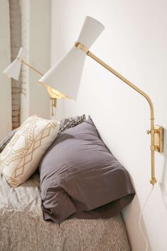 a lamp that is sitting on top of a bed next to a pillow and pillows