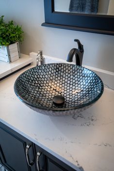 a bathroom sink sitting on top of a counter next to a mirror and plant in the corner