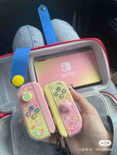 someone is holding two nintendo wii game controllers in their hand, and they are both pink