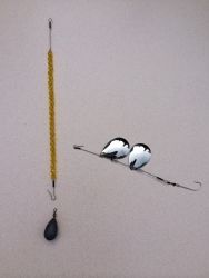 two birds sitting on top of a blue beaded necklace next to a hook with beads