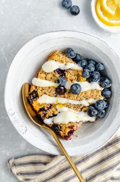 a bowl filled with blueberries and granola next to a cup of yogurt