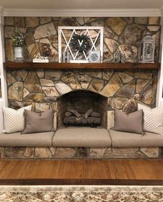 a living room with a stone fireplace and couches