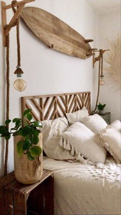 a wooden surfboard mounted to the side of a wall above a bed with pillows