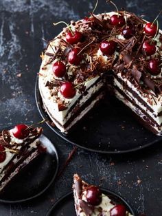 a chocolate cake with cherries on top and one slice missing from the rest of the cake