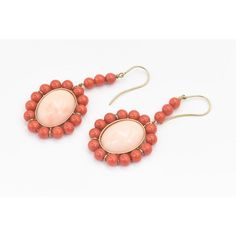 This is part of Chairish’s Fine Jewelry assortment.  These earrings feature a large oval cabochon angel skin coral piece measuring approximately  .80" x .60" set in a frame of orange coral beads measuring approximately 5.5 mm each.  The earrings dangle off an 18k yellow gold wire.  Pierced ears are required to wear these. Formal Coral Jewelry With Cabochon Details, Formal Coral Jewelry With Cabochon, Coral Cabochon Jewelry For Gift, Elegant Oval Coral Jewelry, Elegant Coral Oval Jewelry, Vintage Oval Coral Jewelry, Vintage Coral Oval Jewelry, Coral Oval Jewelry For Gifts, Oval Coral Jewelry For Gift