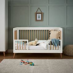 a baby's room with a crib and toys on the floor