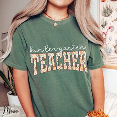 The Floral Kindergarten Teacher Comfort Colors Shirt is the perfect choice for the first day of school. This adorable Kindergarten Shirt makes a thoughtful Back to School Gift for any teacher, blending style and comfort effortlessly. Elevate your style this school season with the Floral Kindergarten Teacher Comfort Colors Shirt! Designed to charm and comfort, it's a must-have for the first day back! Imagine stepping into the classroom, greeted by smiles and this delightful shirt! Crafted with care, it blends cozy comfort with a splash of floral flair, perfect for every teacher's wardrobe. Embrace the joy of teaching with a shirt that speaks volumes about your passion. Soft hues and a touch of whimsy make it an irresistible choice for any educator. Gift yourself or a cherished teacher this Teacher Wardrobe, Fifth Grade Math, Kindergarten Teacher Shirts, Kindergarten Shirts, Christmas Math, Back To School Gift, School Season, Kindergarten Teacher, Comfort Colors Shirt