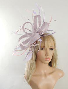 Hats By Cressida Kentucky Derby & Ascot Fascinator Hats Laveder Lilac and Baby Pink Regan Sinamay Fascinator Pretty lilac sinamay loops with lilac and pink coque and biot feathers Fascinator hat body measures about 7-8 Inches wide,longer with feathers Mounted with a matching headband. If you prefer a headband to match your hair, please make a note at check out what colour headband you want. Our Regan Feather Fascinator is ideal for special occasions like Kentucky Derby, Royal Ascot, weddings, church and fancy cocktail parties. With an elegant looped design and feather accents, it's the perfect finishing touch for any look. This fascinator is mounted with a comfortable headband so you can wear all day. We make each hat to order just for you, we would prefer if you did not order for choice. Spring Party Purple Headband, Purple Headpieces For Spring Races, Elegant Purple Headband For Spring, Spring Purple Headband, Adjustable Purple Fascinator For Garden Party, Summer Party Purple Headband, Spring Party Purple Hair Accessories, Purple Hair Accessories For Spring Party, Lavender Headpiece For Kentucky Derby Party