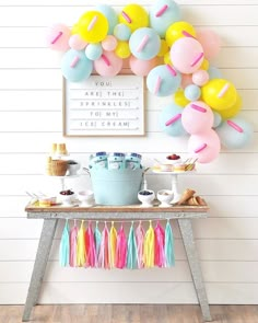 a birthday party with balloons, cake and desserts on a table in front of the wall