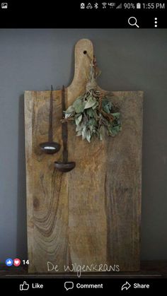 a wooden cutting board with two knives and a plant on it's back end