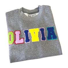 Our Custom mini chenille patch sweatshirt has so many options. It makes the perfect gift and is a great custom option Letters are available in both a white black option and a multi- color option for a fun youthful look. Sweatshirt runs true to size for men and kids. It's suggested women size down for a more fitted look. Women keep your traditional size for a relaxed/oversized fit. 50/50 cotton/poly Double-needle stitching at waistband and cuffs 1x1 rib-knit collar, cuffs, and waistband with span Multicolor Crew Neck Top For Everyday, Everyday Multicolor Crew Neck Top, School Spirit Crew Neck Top With Letter Embroidery, School Spirit Crew Neck T-shirt With Embroidered Text, Varsity Crew Neck Top With Letter Embroidery, Varsity Crew Neck T-shirt With Letter Embroidery, Varsity Style Top With Letter Embroidery And Crew Neck, Varsity Crew Neck Top With Embroidered Text, Multicolor Crew Neck Sweatshirt With Screen Print