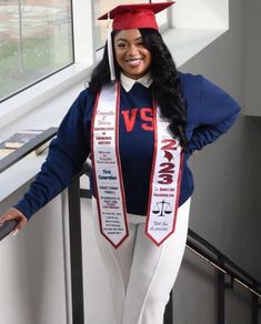 a woman in a graduation cap and gown posing for the camera with her hands on her hips