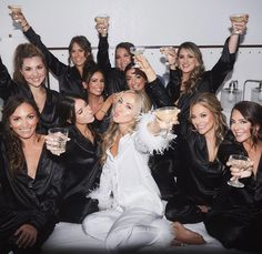 a group of beautiful women sitting next to each other holding wine glasses in their hands