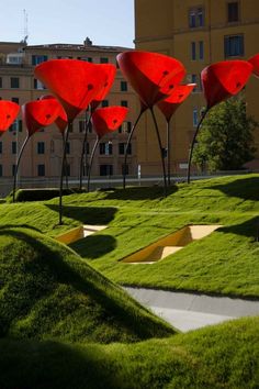 red sculptures in the shape of flowers on top of green grass