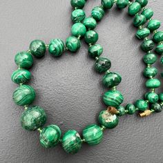 Vintage ~ Graduating size ~ genuine round  Malachite beaded choker necklace with barrel clasp and smaller glass seed beads between each malachite bead. Unsigned  Dates : Mid to late 20th century  Measurements : Necklace is 22 inches in max length   x  little shy to 5/8   inches max width ~ Largest bead is little shy to 5/8  inches in diameter ~ Smallest is 1/4 inches in diameter . Weighs 110 inches on my weighing scale . Condition : Necklace is in good wearable condition with No cracks or chips to the malachite cab , only for some light surface wear to the metal and stones ( nothing noticeable ) ~ As stones are natural they have some irregularities  . Please Note ~ As Antique /vintage items are previously loved /used please do expect some minor wear like surface wear /dents /dings and meta Malachite Gemstone Bead Necklaces, Malachite Gemstone Beads Necklace, Beaded Malachite Round Bead Necklaces, Malachite Gemstone Beads Jewelry, Round Malachite Gemstone Bead Jewelry, Polished Malachite Round Beaded Necklaces, Malachite Gemstone Beaded Necklaces, Handmade Malachite Round Bead Necklace, Round Malachite Beaded Necklace