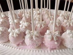 there are many pink and white candies on the plate with toothpicks in them