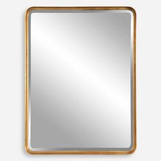 a square gold framed mirror on a white wall, with the reflection of a person in it