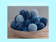 a bowl filled with blue balls on top of a wooden table