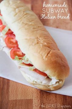 a sub sandwich with tomatoes and lettuce on it