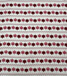 a red and white knitted fabric with leaves on the front, in various colors