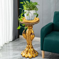 a green chair sitting next to a table with a potted plant on it