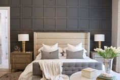 a bedroom with gray walls and white bedding