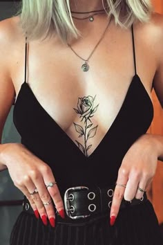 a woman wearing a black dress with a rose tattoo on her chest and two rings around her waist