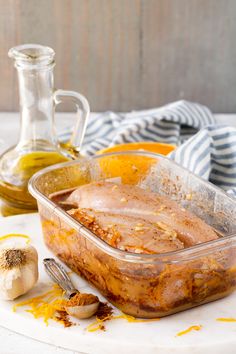 a casserole dish on a plate with garlic and orange peels next to it