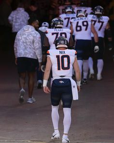 the football players are walking down the field