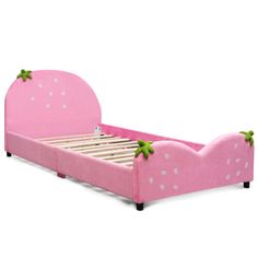 a pink bed with white polka dots and green leaves on the headboard, sitting in front of a white background