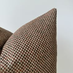 a brown and white checkered pillow sitting on top of a chair