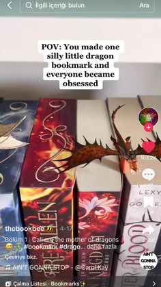 an image of a dragon on top of some books with the caption pov you made one silly little dragon bookmark and everyone came to these boxes