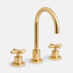 two gold faucets with handles on each side, one is turned to the right