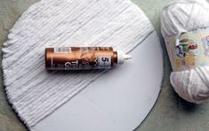 a white ball of yarn next to a brown battery