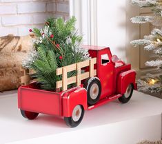 a red toy truck with a christmas tree in the back