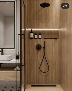 a bathroom with a wooden wall and black shower faucet next to the bathtub