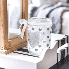 a glass jar sitting on top of a white table next to a wooden framed mirror