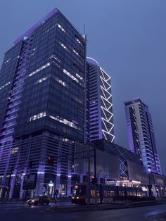 two tall buildings are lit up at night