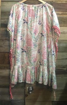 Bohemian floral print tunic cover up with multi-colored pom-pom trims. Tie up front with beads details. Ruffle trim at the bottom.Wear it as a cover up to beach, or as a top to pair with capri / jeans/ legging. Super cute to wear with sandals or boots. Very boho chic!One size fits most. Loose relaxed fit.Materials:Soft cottonMeasurements:Length: 33"Width (lay flat across): 37" fits up to 24" (about 45" waist)Note: Clearance items are final, non-refundable, except for quality issues. Multicolor Spring Kaftan With Back Tassel Tie-up, Bohemian Multicolor Tassel Cover-up, Multicolor Vacation Kaftan With Tassels, Multicolor Kaftan With Back Tassel Tie-up For Summer, Multicolor Tasseled Kaftan For Vacation, Multicolor Tassel Kaftan For Vacation, Spring Multicolor Kaftan With Tassels, Bohemian Multicolor Kaftan With Back Tassel Tie-up, Spring Kaftan With Tassel Ties