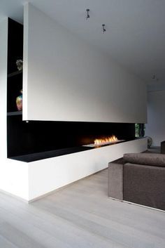 a living room with a couch and fire place in the corner on the wall next to it