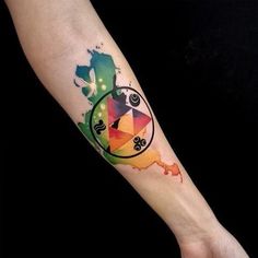 a person with a tattoo on their arm has a colorful clock and watercolor paint