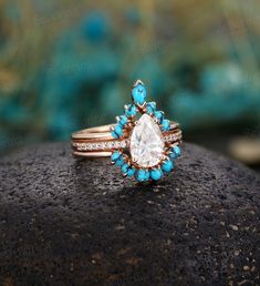 a close up of a ring on top of a rock with blue and white stones