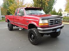 a red pick up truck parked in a parking lot